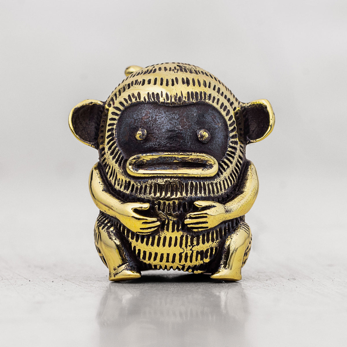 Gold and black monkey finger puppet figurine on a white background