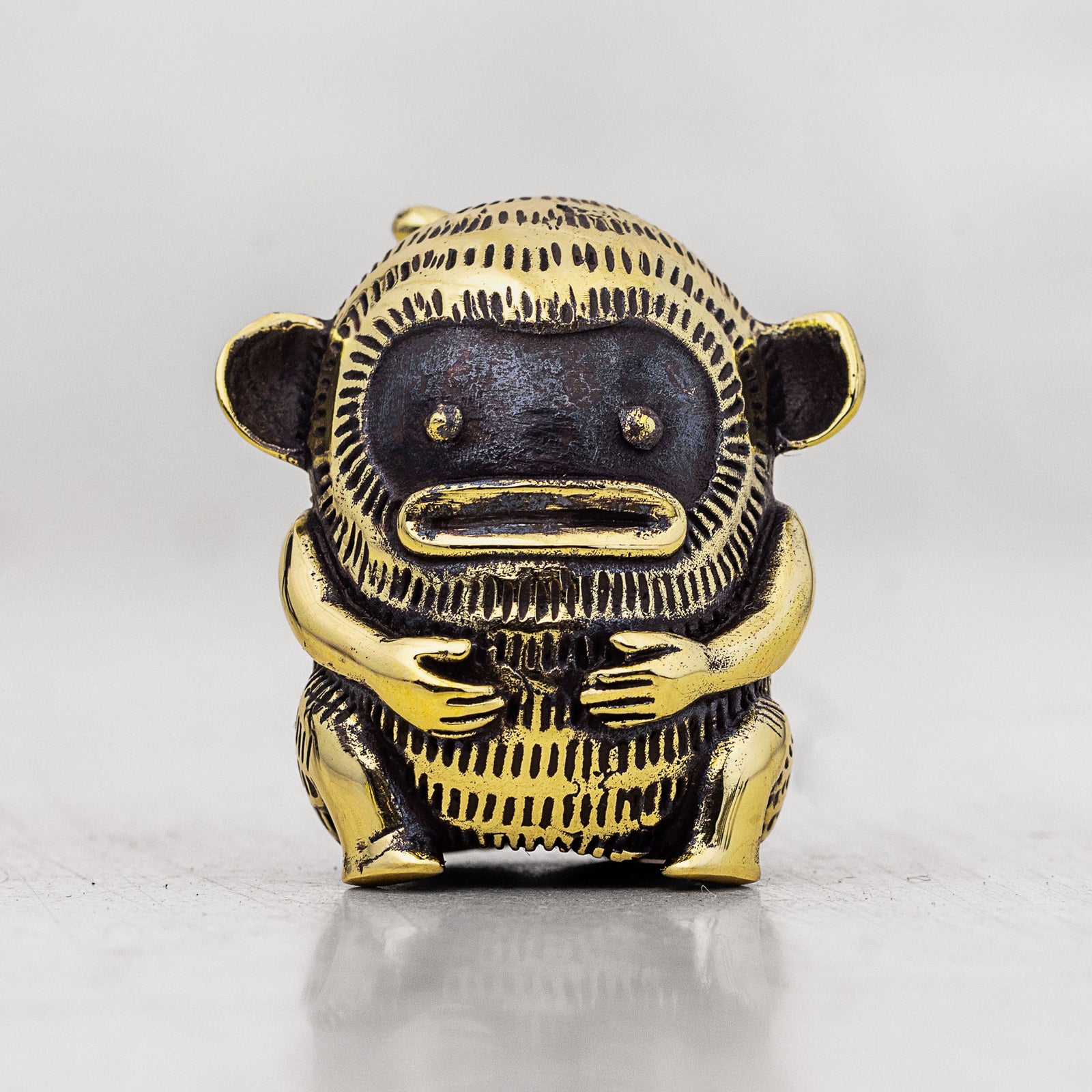 Gold and black monkey finger puppet figurine on a white background
