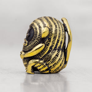 Gold and black brass monkey figurine with intricate design on a white background