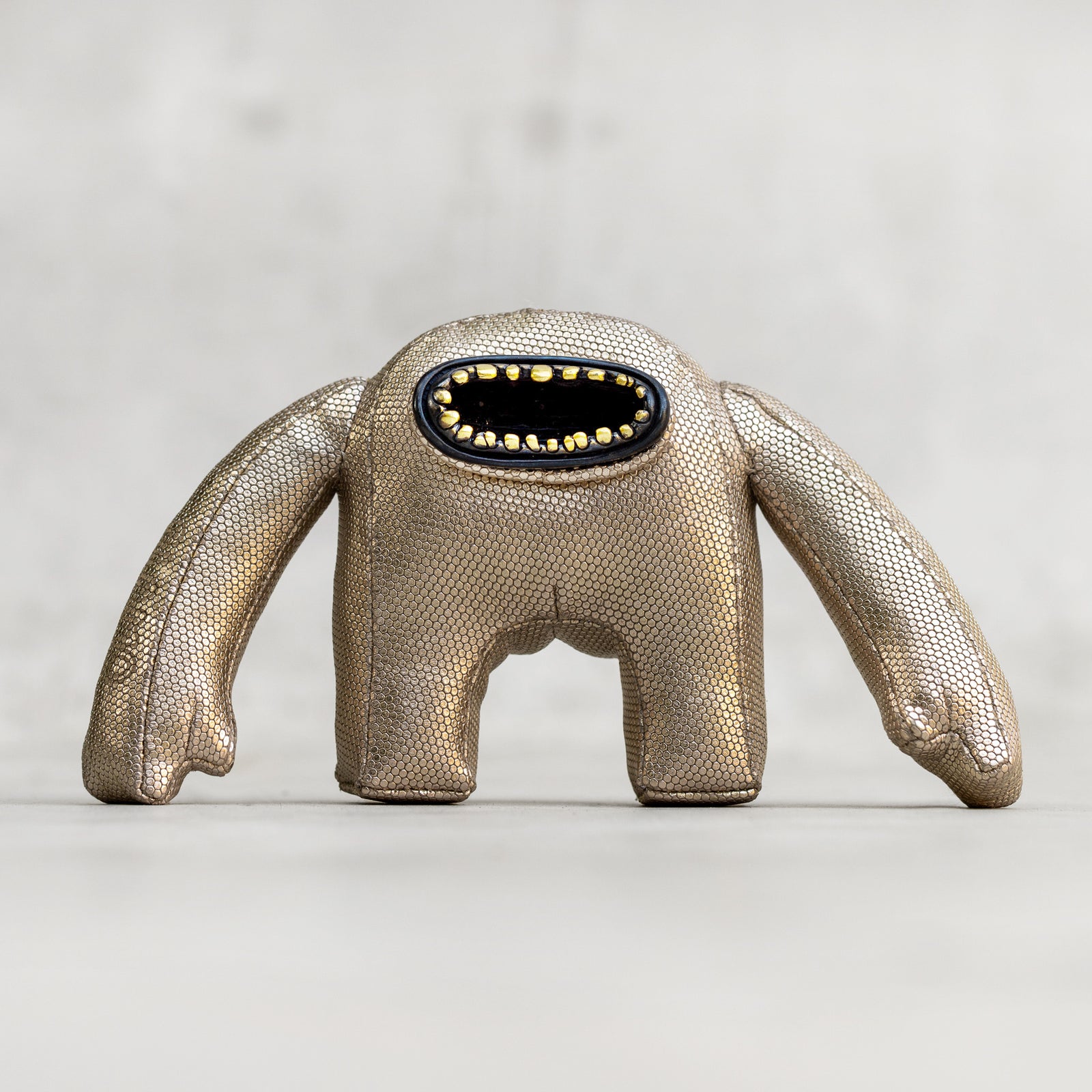 Metallic creature toy on a light background