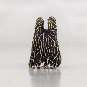 A black textured sculptural figurine with gold vein-like detailing, shown on a neutral light gray background.