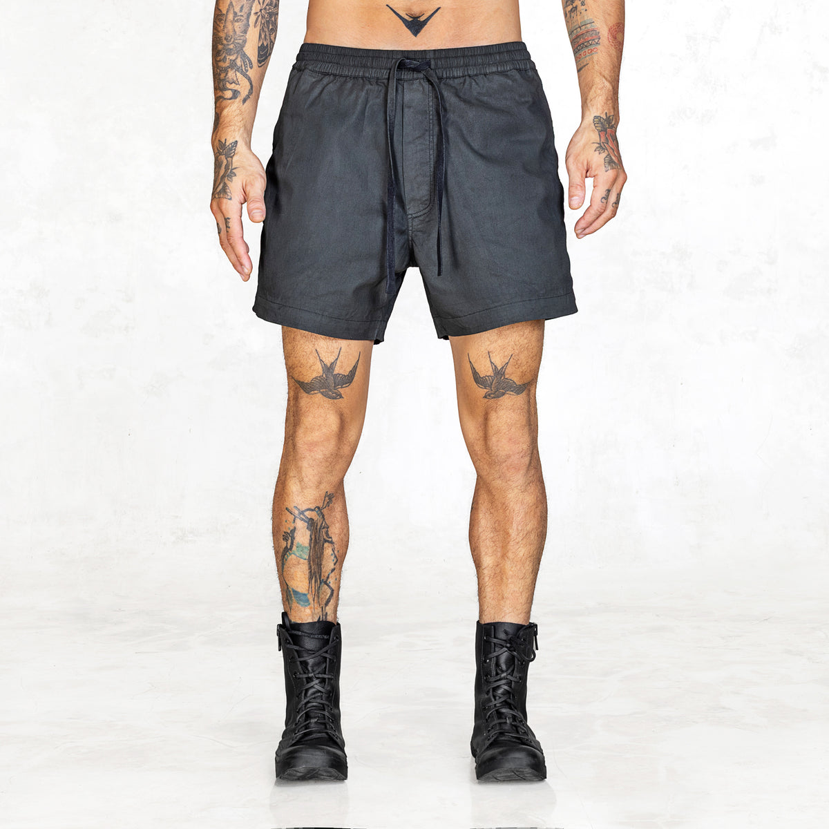 Person wearing black shorts on a white background