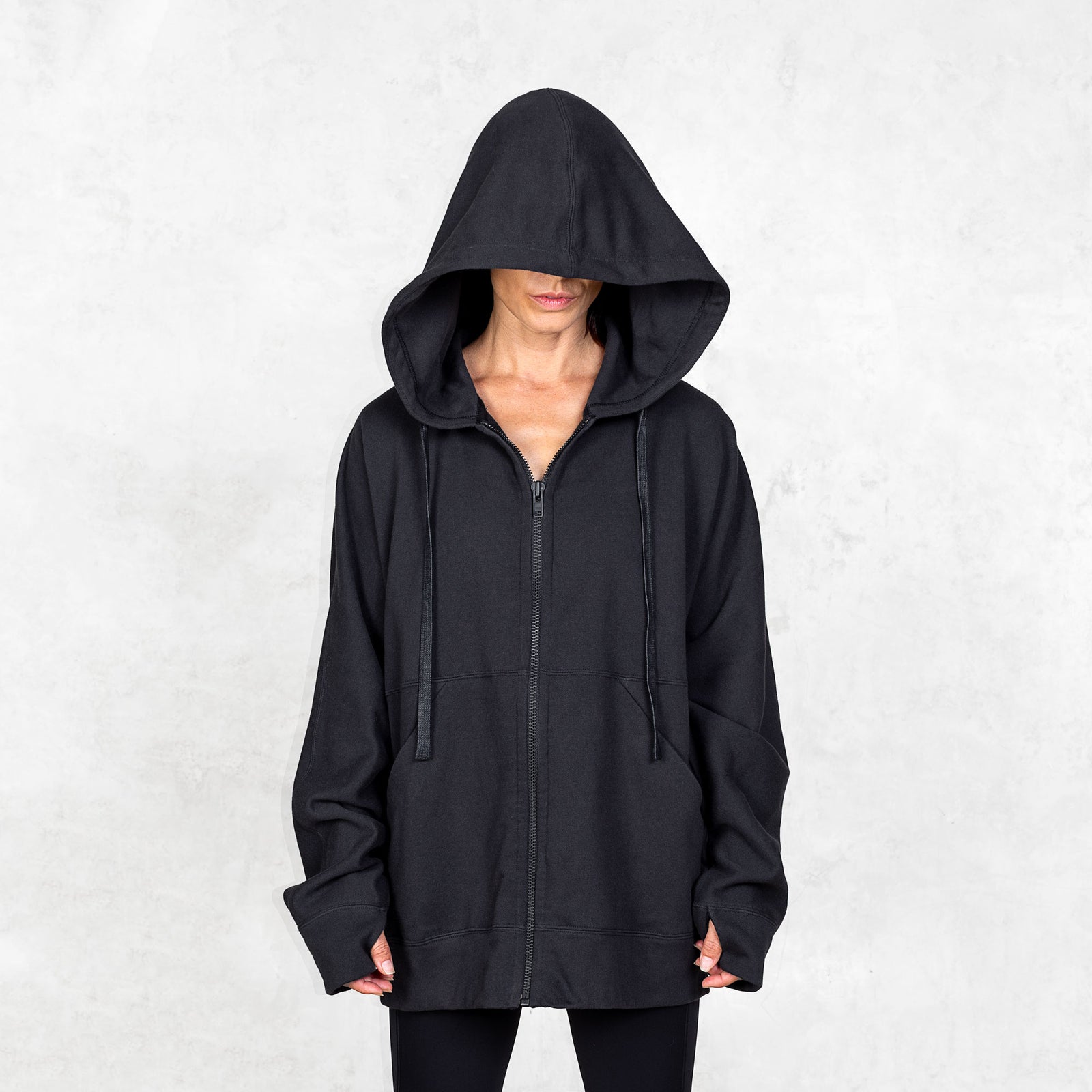 Person wearing a black hoodie against a white background
