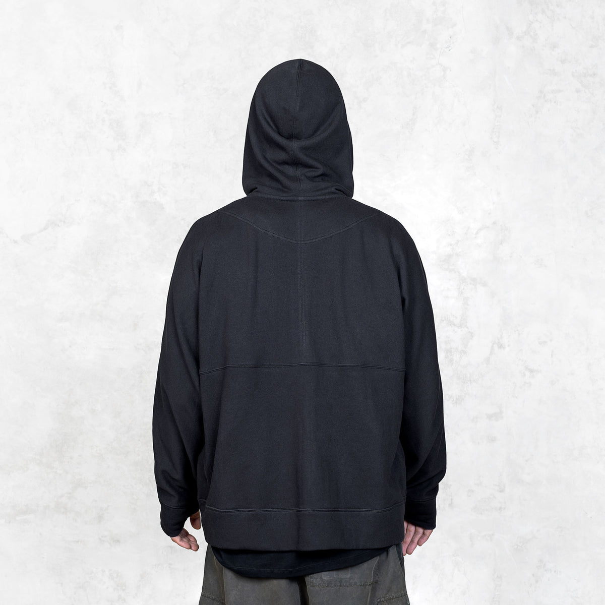 Person wearing a black hoodie from behind on a white background