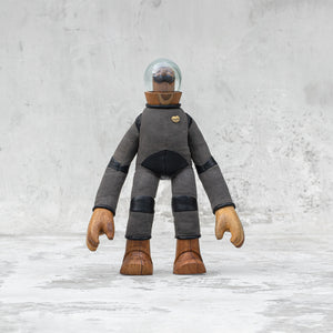 Leather wood and glass astronaut with a mustache statuette standing against a light gray background