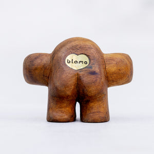 Small wooden sculpture with arms extended in a HUG position and smoky quartz gem eyes