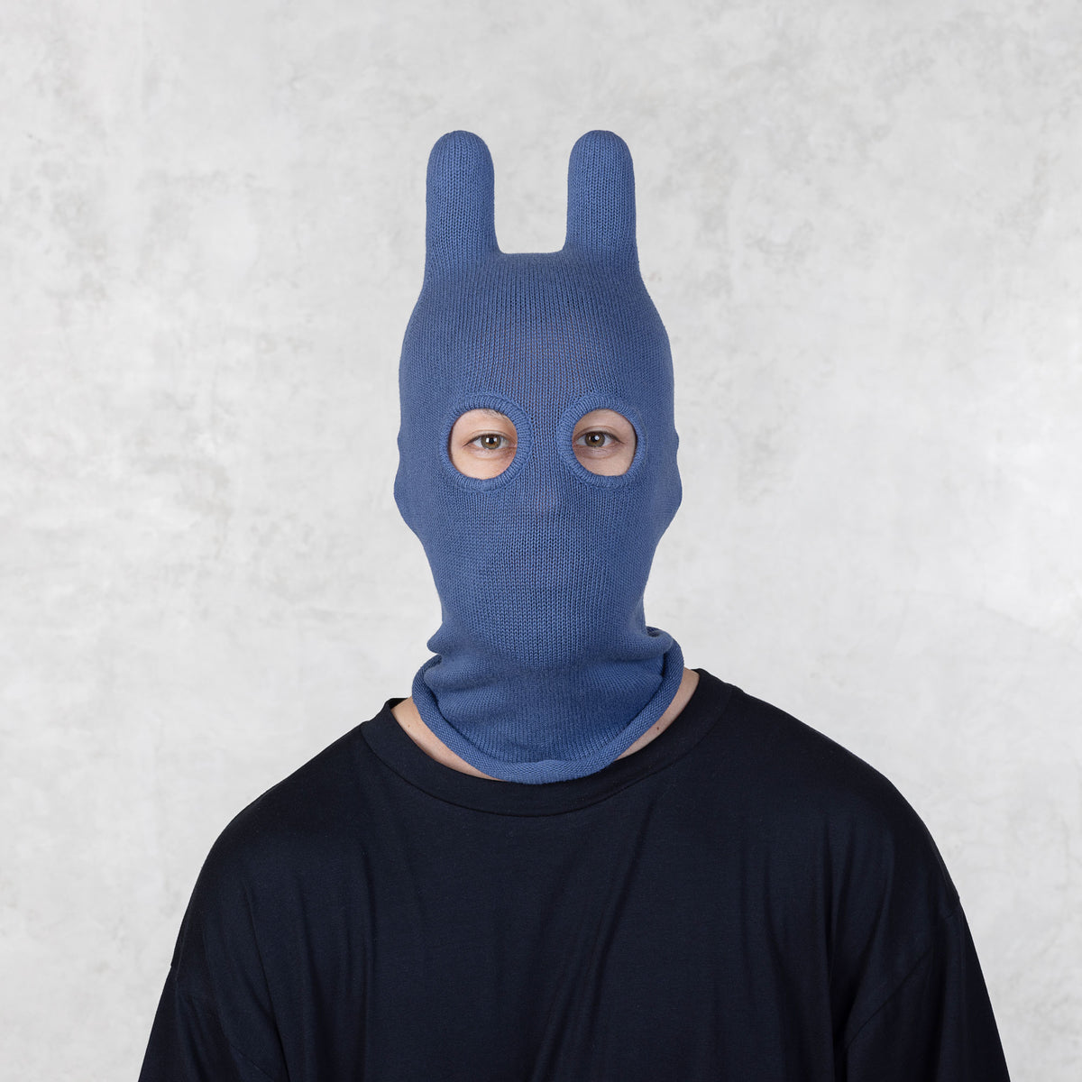 Front view of a Person wearing a blue balaclava against a light gray background