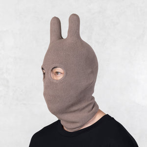 Person wearing a Blamo Socky Balaclava Haze brown knit bunny mask against a white background