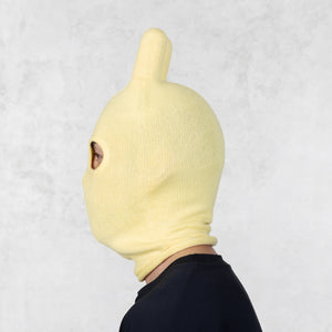 Person wearing a yellow knit mask on a light gray background