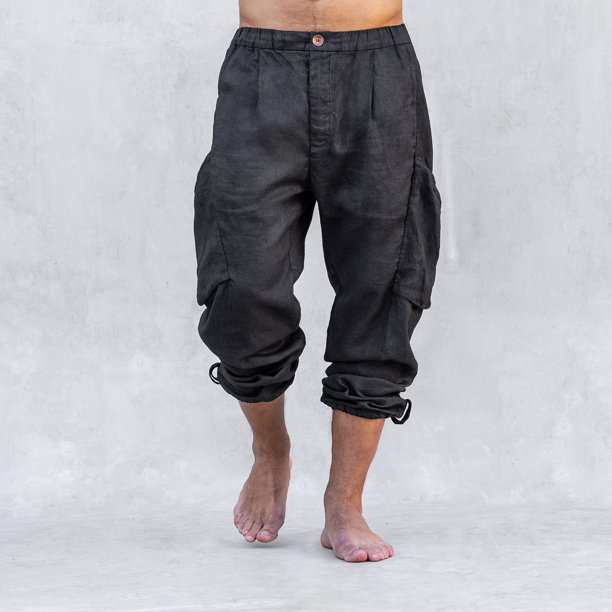 A man wearing a pair of cargo style linen BLAMO linen pants standing from the waist down facing front. 