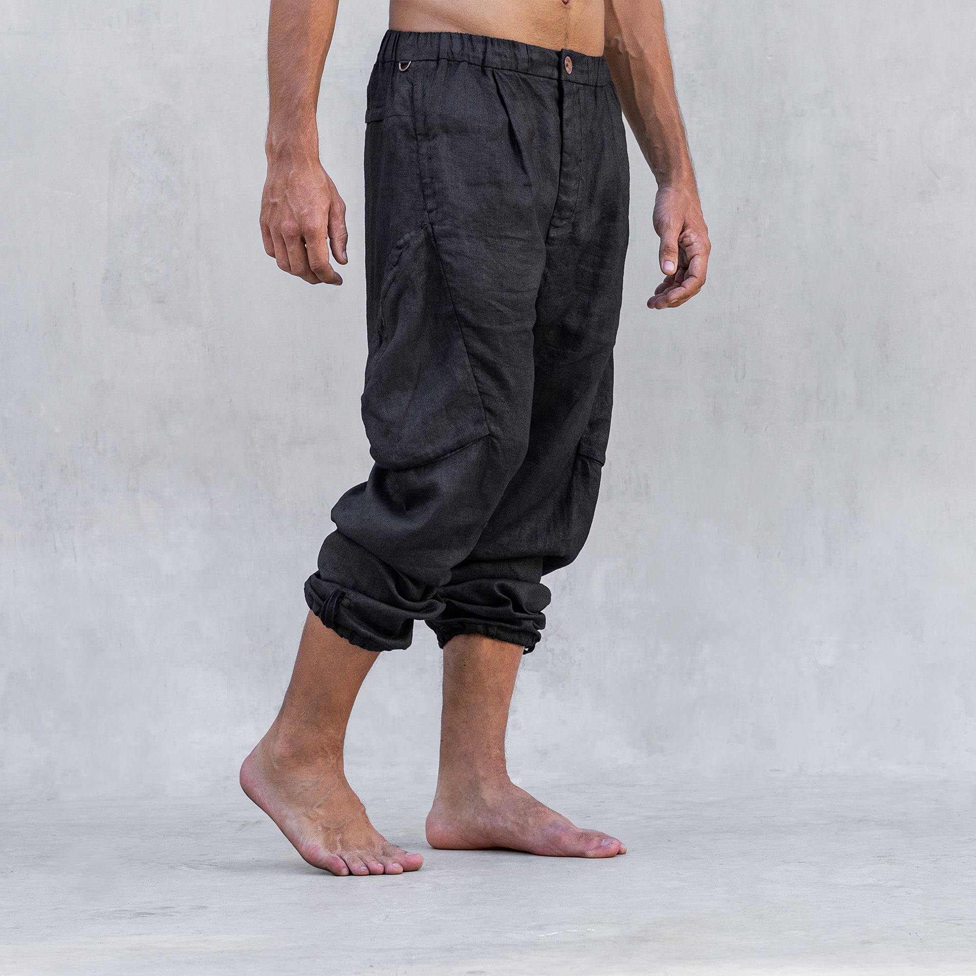 A man wearing a pair of cargo style linen BLAMO linen pants standing from the waist down facing side