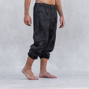 A man wearing a pair of cargo style linen BLAMO linen pants standing from the waist down facing side