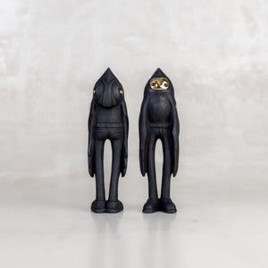 Two black birdman figurines facing forwards and backwards on a white background