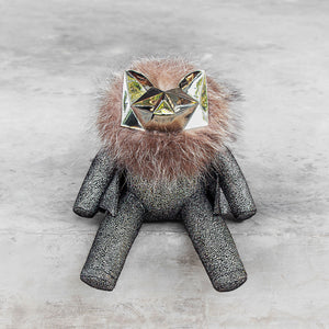 Sparkly leather stuffed toy with a brass head and fur on a gray background