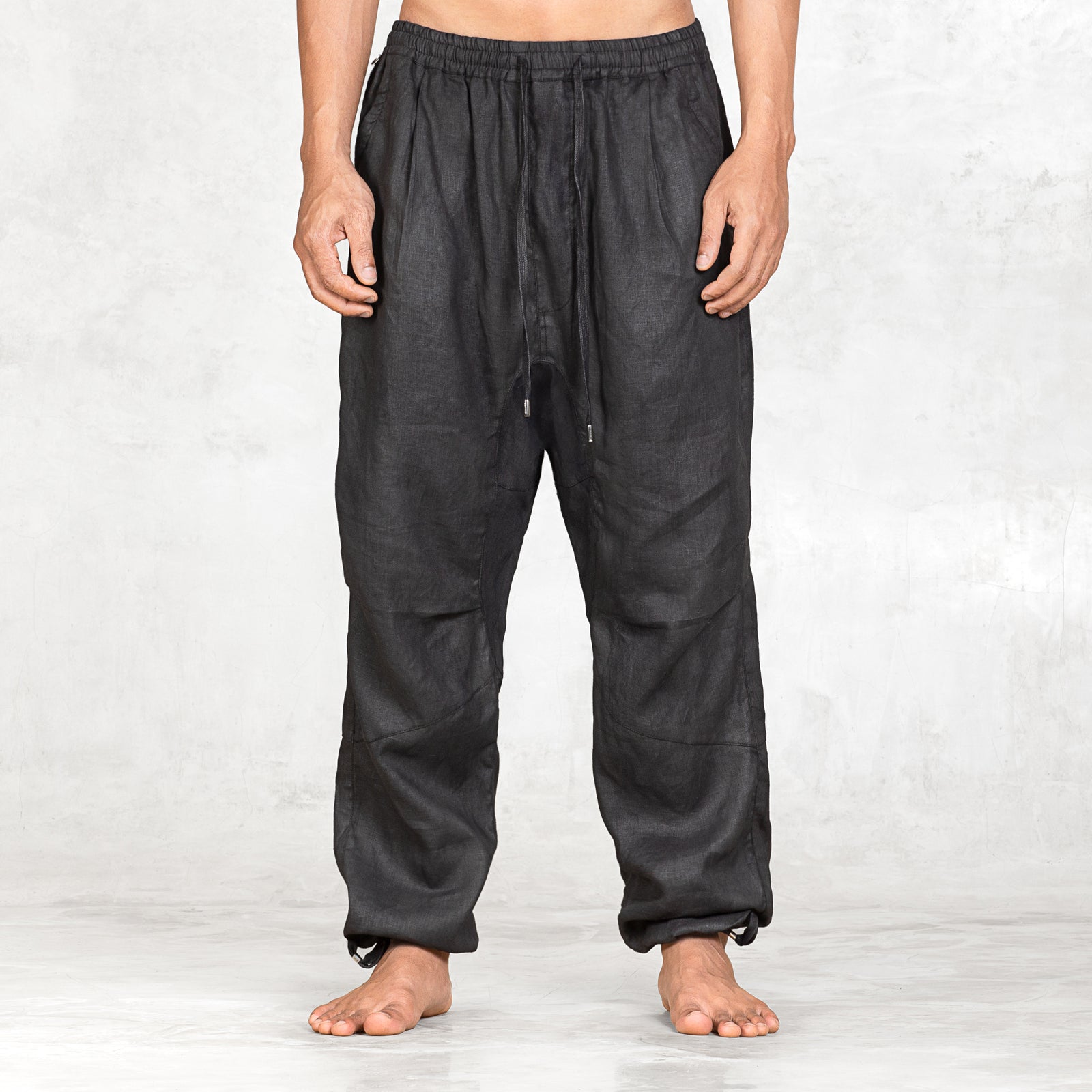 Person wearing black baggy pants on a white background