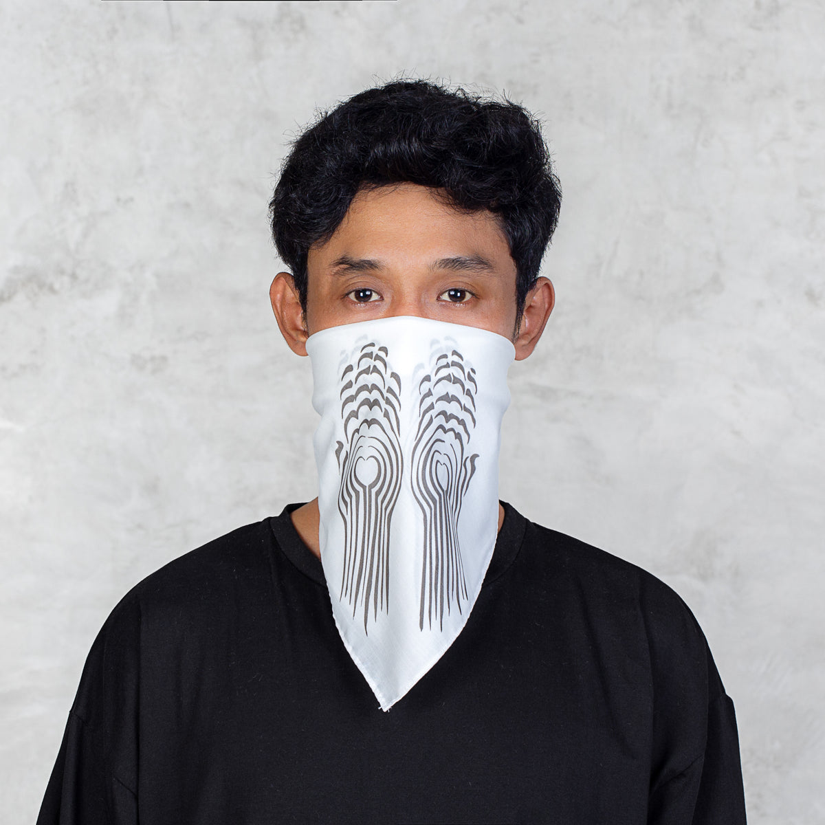 A man wearing a white bandana-style face mask with a black abstract line pattern, paired with a black t-shirt, set against a textured light gray background.