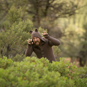 Person wearing a bear costume in a forest setting