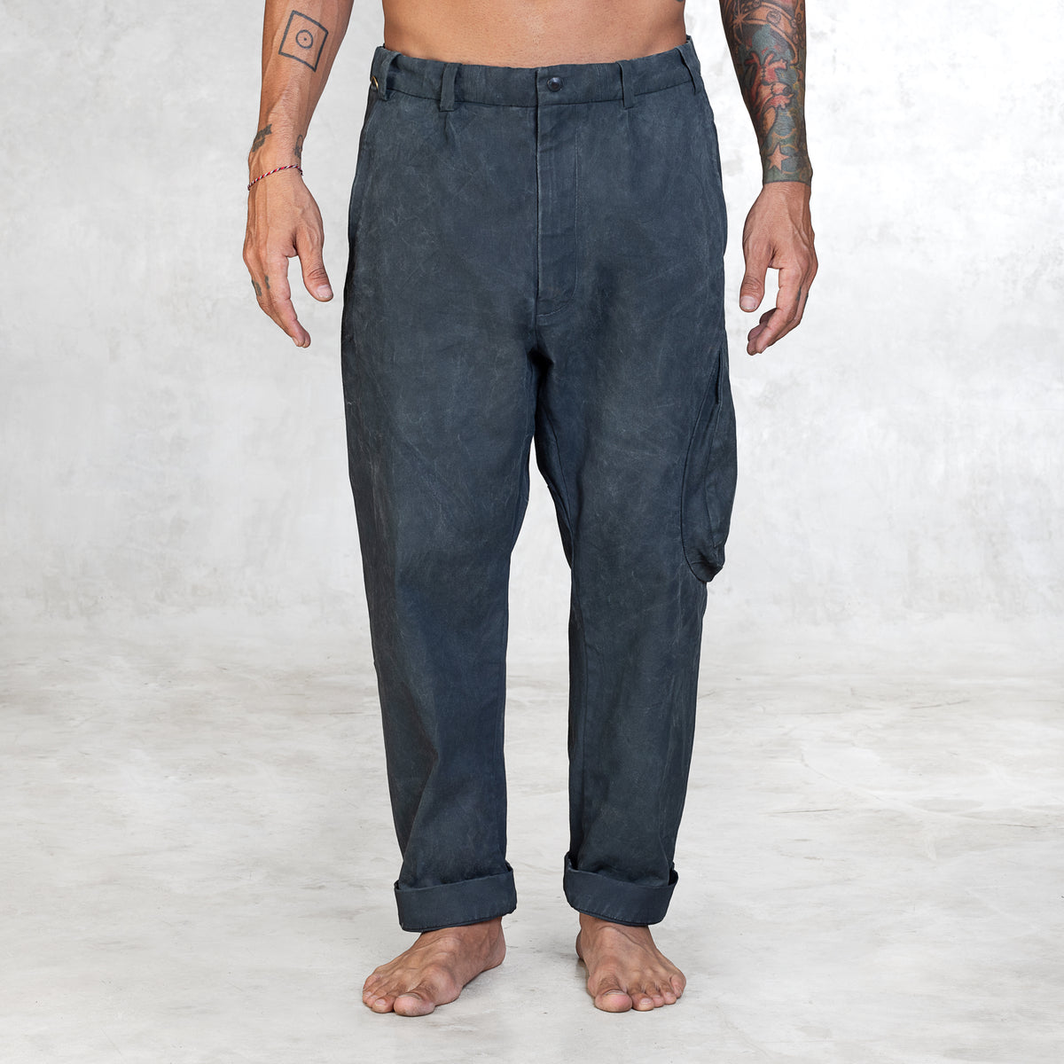 Man from waist down wearing cargo style indigo blue pants