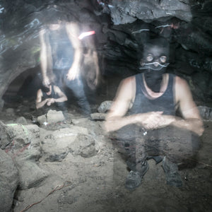 Blurry photo of people wearing dark clothing in a cave
