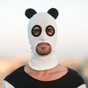 Person wearing a panda-themed balaclava with a blurred background