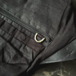 Closeups of details of a black crossbody bag