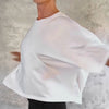 Person in a white cropped t-shirt spinning and moving their arms around