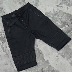 Closeups of details of a pair of black ridged button up belted shorts