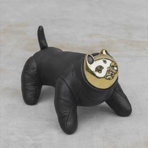 Black Leather and Gold Brass Cat figurine rolling and walking on a gray surface