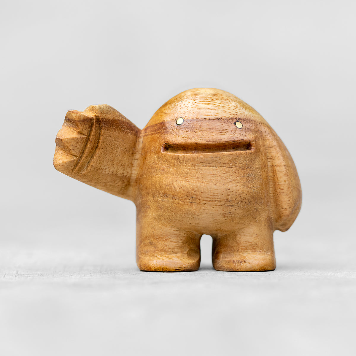 A small wood sculpture giving a high 5 