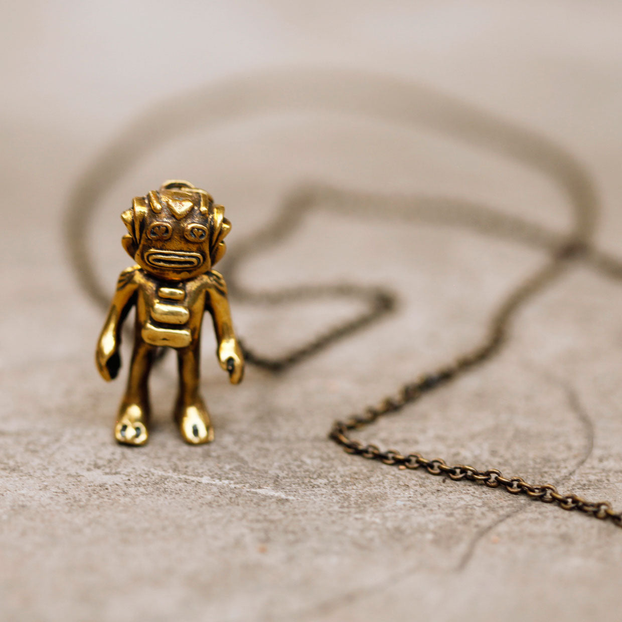 Brass Swamp monster charm pendant on a brass necklace chain